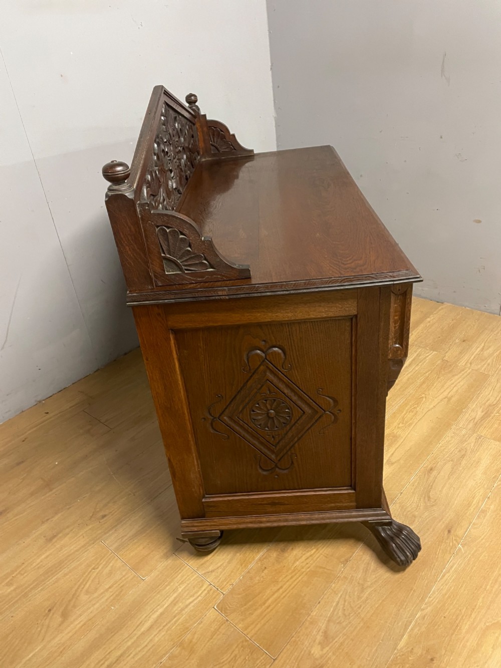 A nineteenth-century carved oak sideboard featuring a backboard gallery decorated with a Green Man motif, two geometric drawers, and two panelled cupboard doors. View VIII