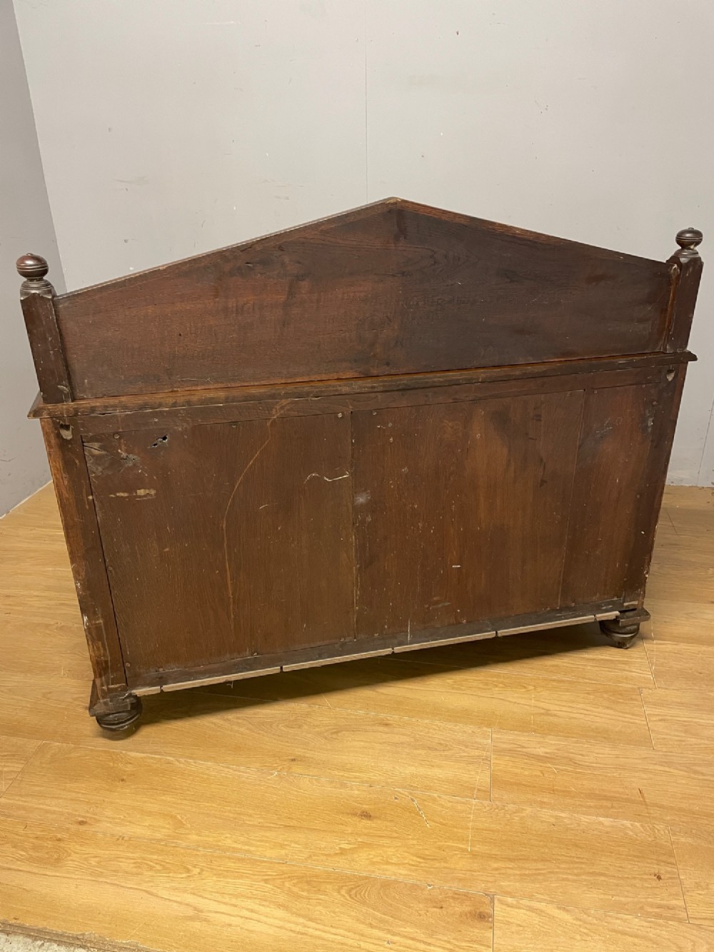 A nineteenth-century carved oak sideboard featuring a backboard gallery decorated with a Green Man motif, two geometric drawers, and two panelled cupboard doors. View X