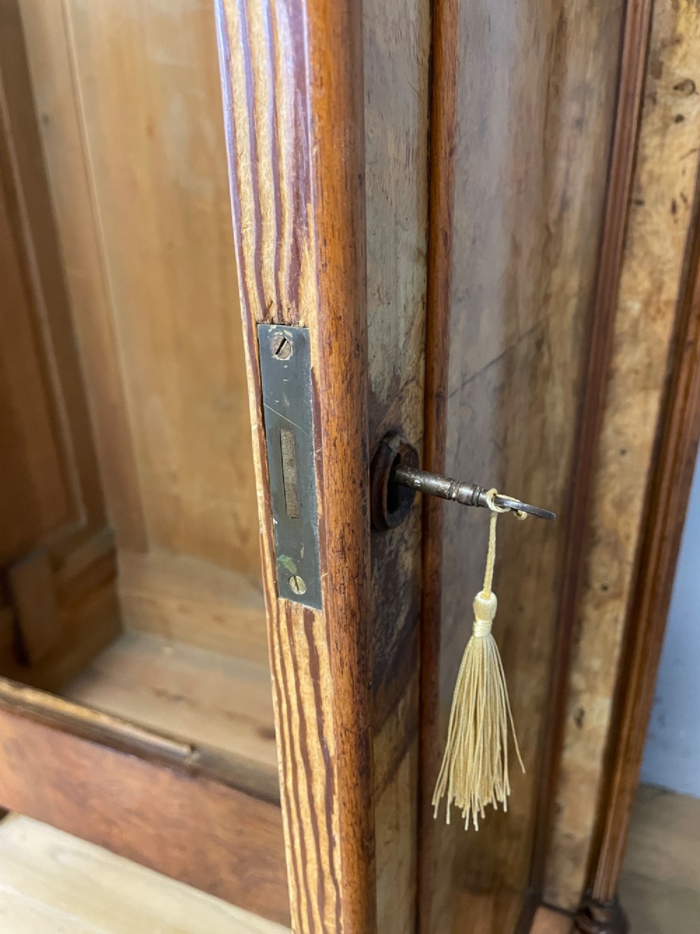 A nineteenth-century French figured walnut two-door armoire featuring an arched cornice with turned corner finials and a central circular moulding. View VII