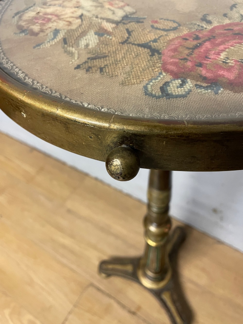 A 19th-century gilt and ebonised torchere stand featuring a circular needlework top, a turned column stem, and tripod feet. View VI