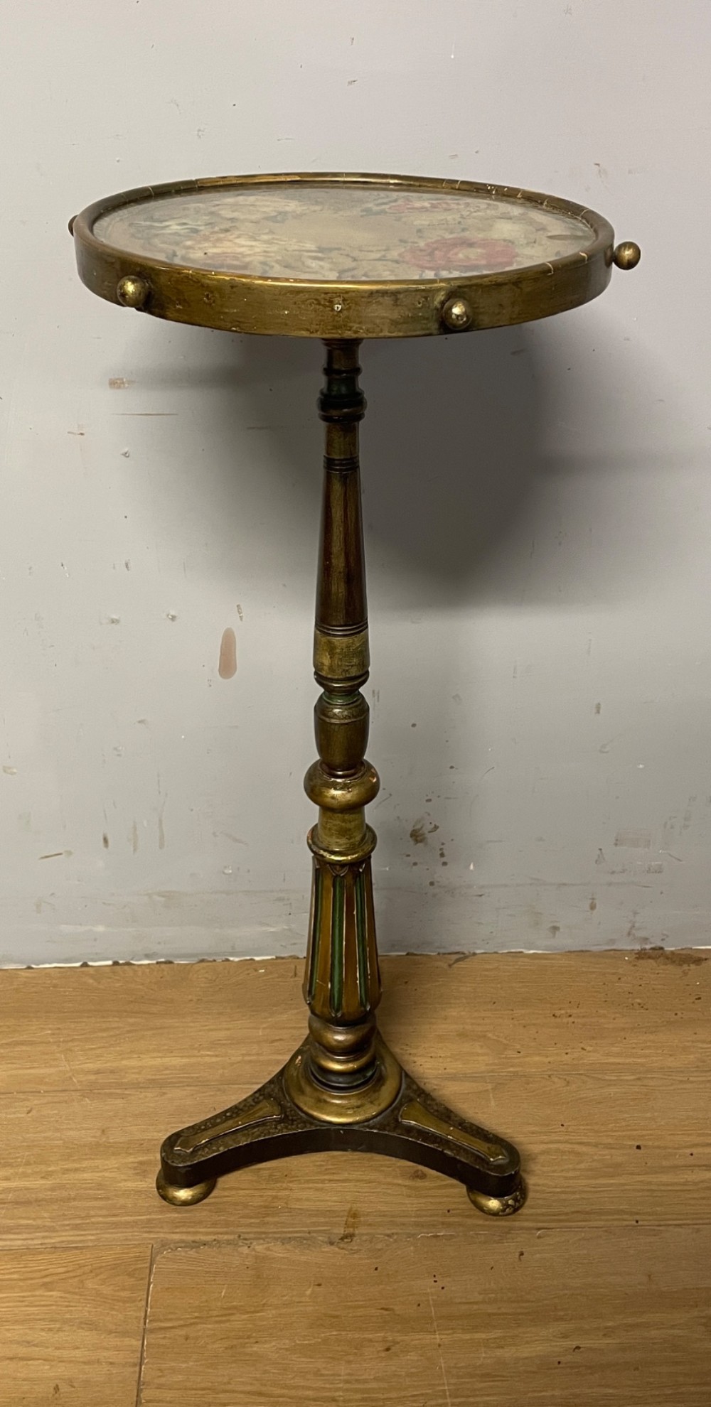 A 19th-century gilt and ebonised torchere stand featuring a circular needlework top, a turned column stem, and tripod feet. View IX