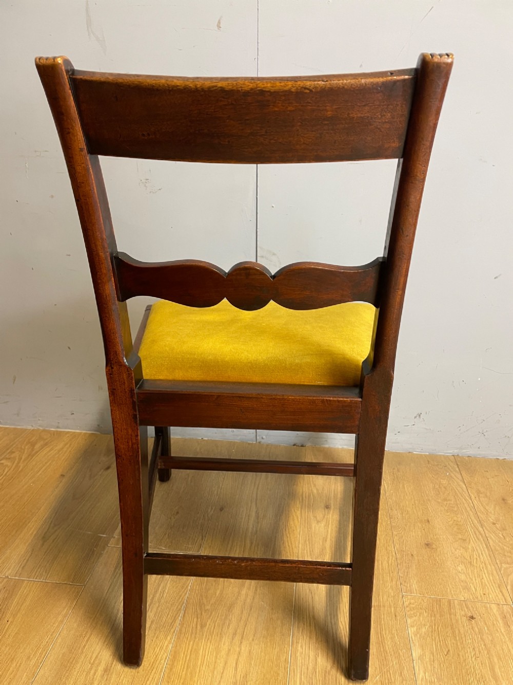 A set of six Georgian mahogany dining chairs featuring reeded frames, carved back rails with roundels, square legs with stretchers, and gold velvet seats. View VII