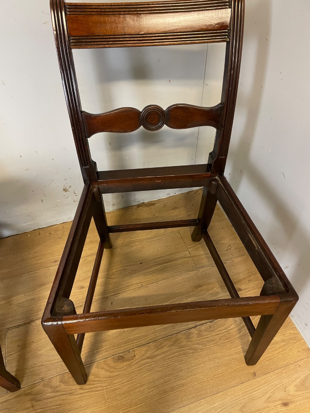A set of six Georgian mahogany dining chairs featuring reeded frames, carved back rails with roundels, square legs with stretchers, and gold velvet seats. View VIII