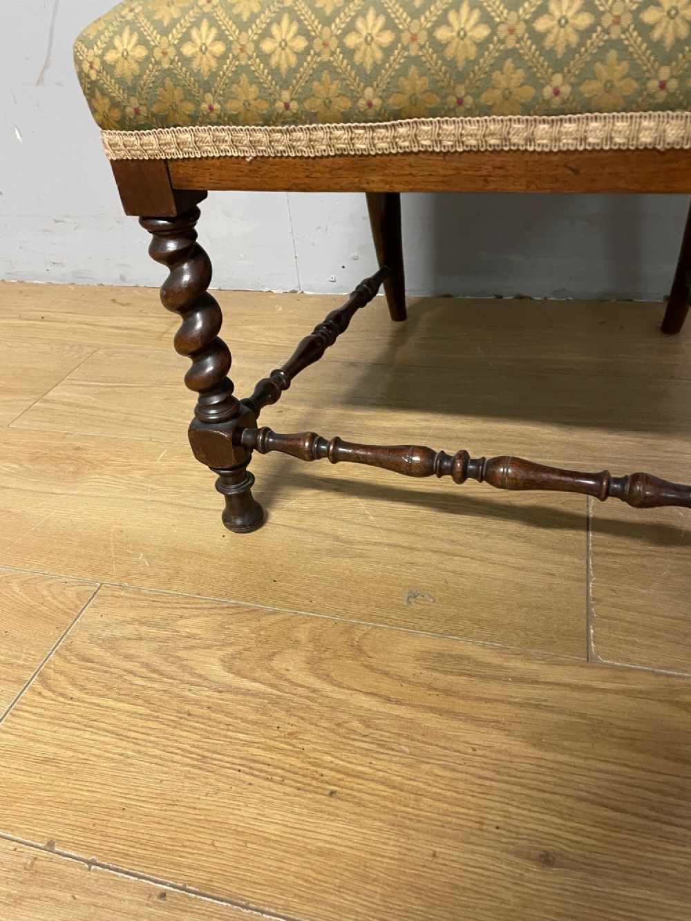 A nineteenth-century carved rosewood nursing chair featuring barley twist uprights, scrollwork cresting, and patterned green upholstery on the seat and back panel. View IV