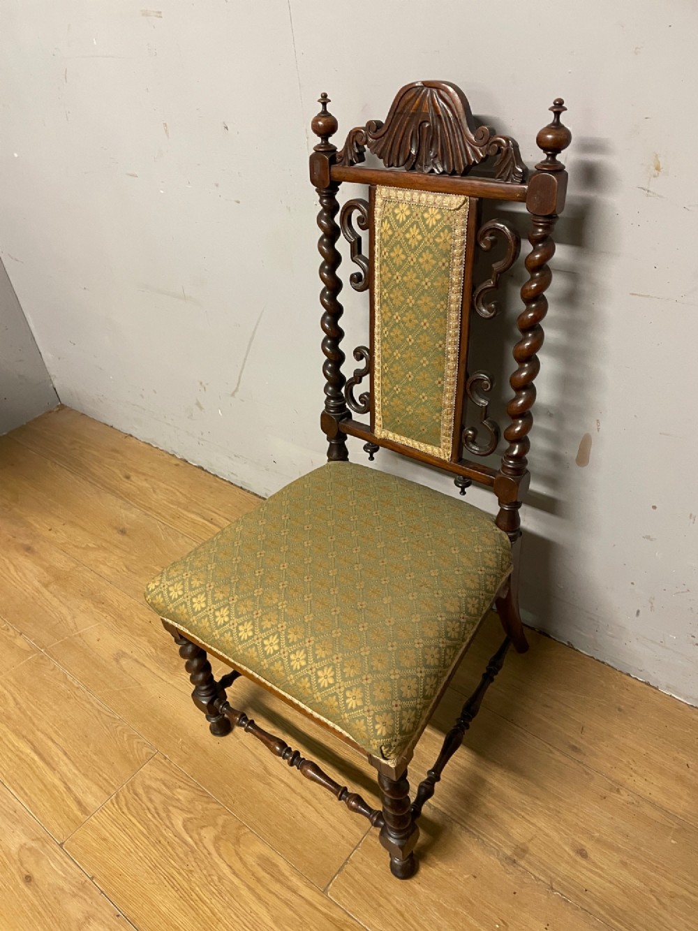 A nineteenth-century carved rosewood nursing chair featuring barley twist uprights, scrollwork cresting, and patterned green upholstery on the seat and back panel. View VIII