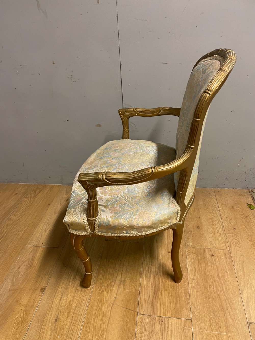 A three-piece Edwardian French style giltwood salon suite comprising a two-seater sofa and two matching armchairs upholstered in patterned cream silk fabric. View VII