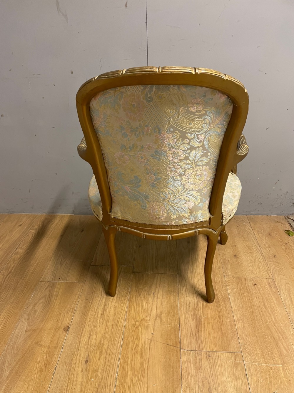 A three-piece Edwardian French style giltwood salon suite comprising a two-seater sofa and two matching armchairs upholstered in patterned cream silk fabric. View VIII