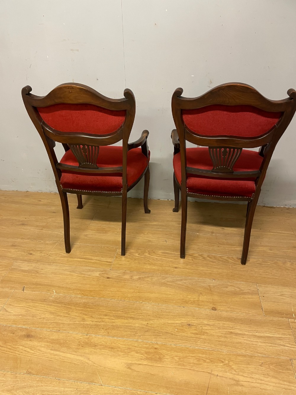A pair of nineteenth-century Empire style mahogany armchairs upholstered in deep red velvet with decorative stud trimming. View VI