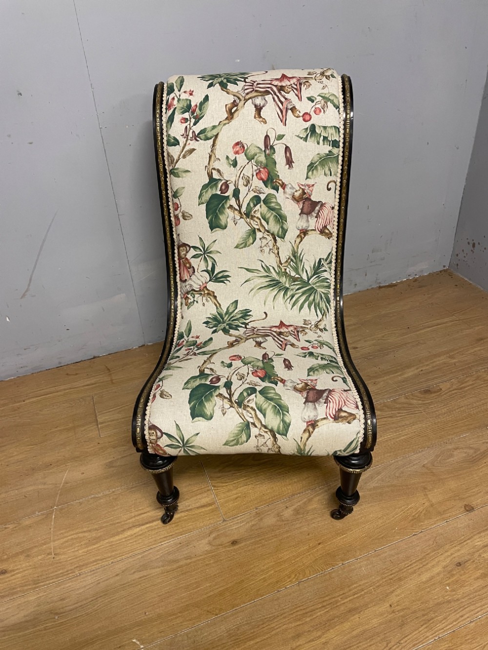 A 19th-century Aesthetic Movement slipper chair featuring an ebonised wood frame accented with gilt ormolu mounts and upholstered in botanical fabric. View III