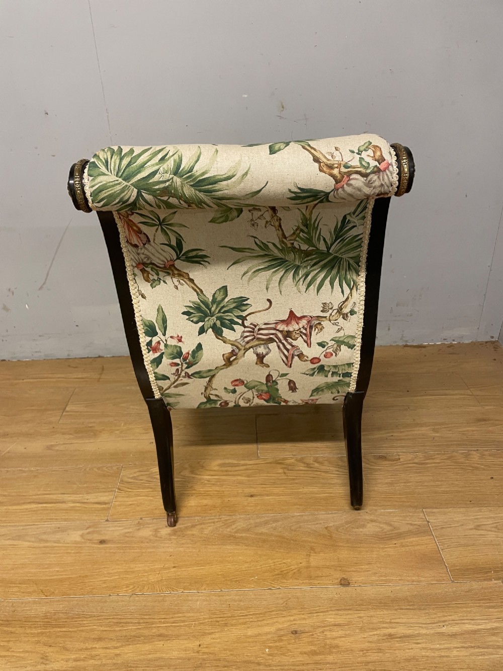 A 19th-century Aesthetic Movement slipper chair featuring an ebonised wood frame accented with gilt ormolu mounts and upholstered in botanical fabric. View VI