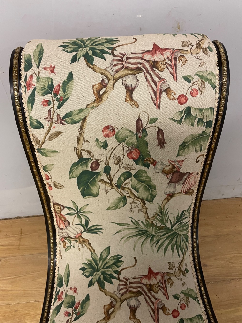 A 19th-century Aesthetic Movement slipper chair featuring an ebonised wood frame accented with gilt ormolu mounts and upholstered in botanical fabric. View VIII