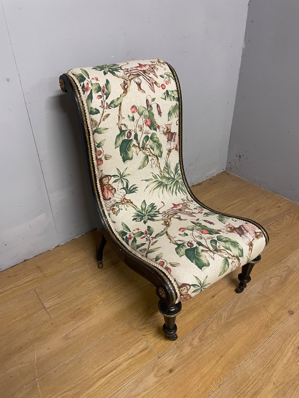 A 19th-century Aesthetic Movement slipper chair featuring an ebonised wood frame accented with gilt ormolu mounts and upholstered in botanical fabric. View XI