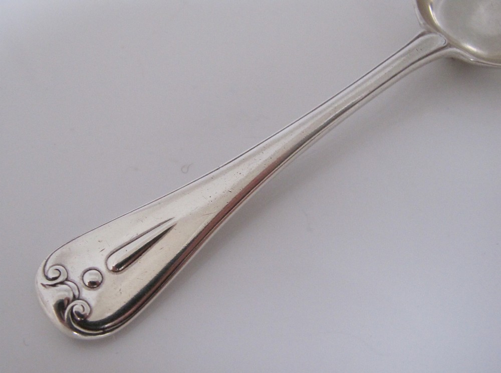 A Victorian sterling silver jam spoon featuring a shovel-shaped rectangular bowl and a decorated Hanoverian pattern handle with scroll terminal. View II