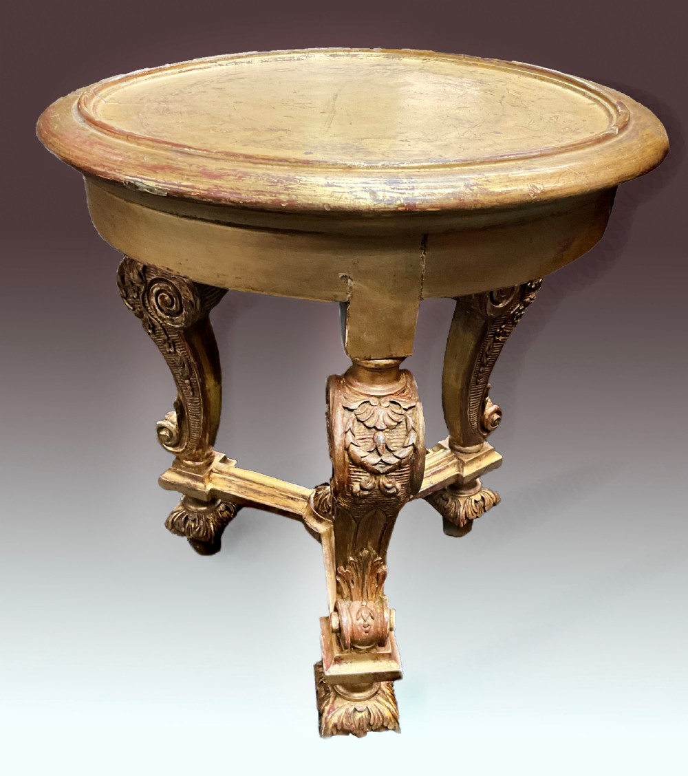 A late nineteenth-century circular giltwood urn stand featuring carved scroll legs, an X-form stretcher, and a dished circular top.