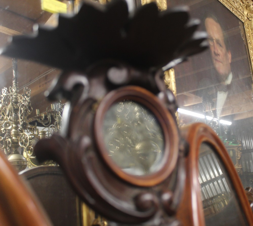 An antique Victorian carved mahogany dressing table mirror with dual oval adjustable mirrors on a central carved column and curved wooden base. View VI