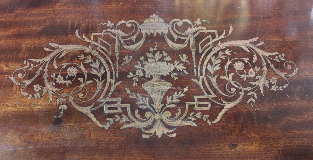 An antique French mahogany side table with brass mounts, inlaid top design, turned fluted legs, and a curved X-stretcher with a brass urn finial. View VIII