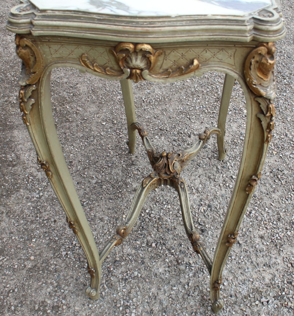 A Louis XV style side table featuring a white and grey veined marble top resting on a painted frame with gilded shell motifs and cabriole legs. View II
