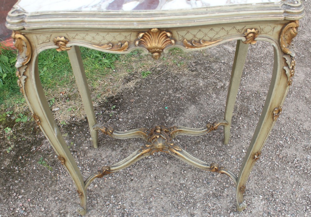 A Louis XV style side table featuring a white and grey veined marble top resting on a painted frame with gilded shell motifs and cabriole legs. View III