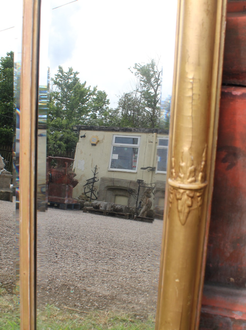 A wide gilded landscape overmantel mirror featuring three glass panels flanked by fluted columns and topped with a decorative foliate frieze. View III
