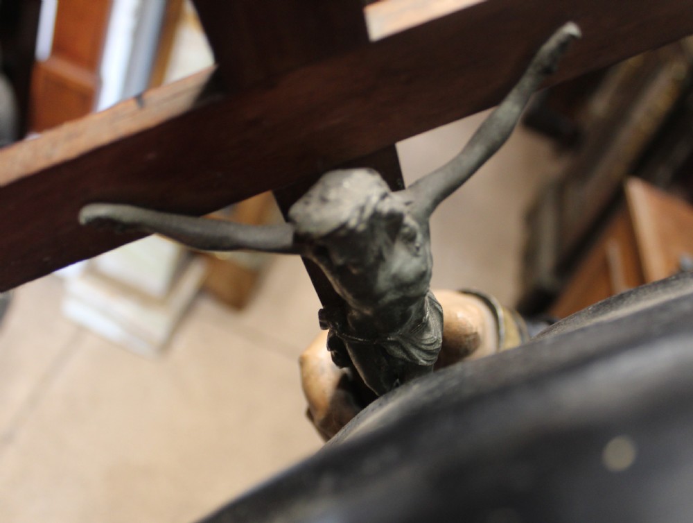A polychrome carved wooden figure of a tonsured saint in a black hooded habit with gold trim, holding a crucifix with one foot resting on a globe. View VIII