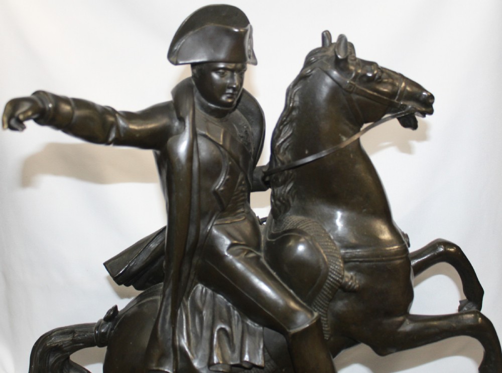 A patinated bronze sculpture depicting Napoleon Bonaparte riding a rearing horse, mounted on a polished green marble rectangular base. View II