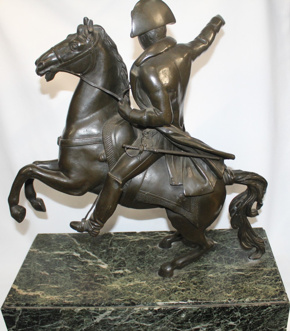 A patinated bronze sculpture depicting Napoleon Bonaparte riding a rearing horse, mounted on a polished green marble rectangular base. View IV