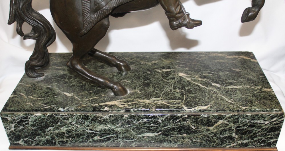 A patinated bronze sculpture depicting Napoleon Bonaparte riding a rearing horse, mounted on a polished green marble rectangular base. View VI