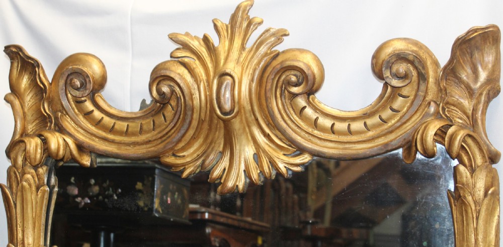 A tall rectangular antique mirror featuring an ornate gilded frame decorated with carved palm leaves along the side columns and a central leaf crest at the top. View II