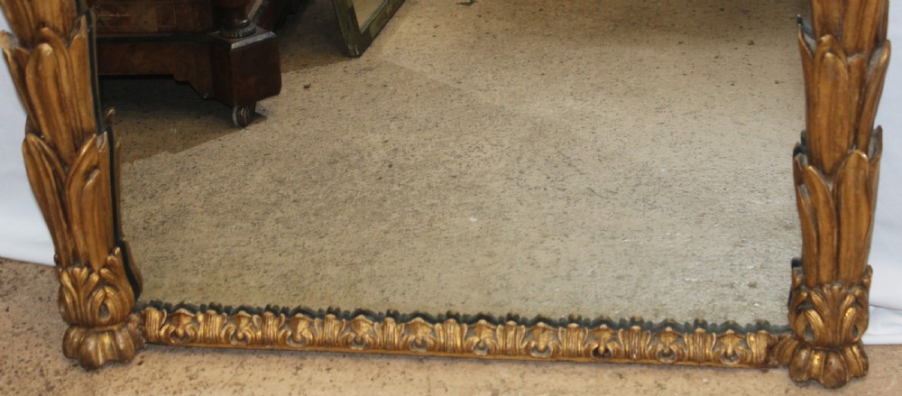 A tall rectangular antique mirror featuring an ornate gilded frame decorated with carved palm leaves along the side columns and a central leaf crest at the top. View III