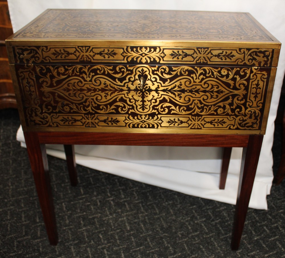An antique brass and tortoiseshell Boulle work writing box mounted on a dark rosewood stand with tapered square legs.