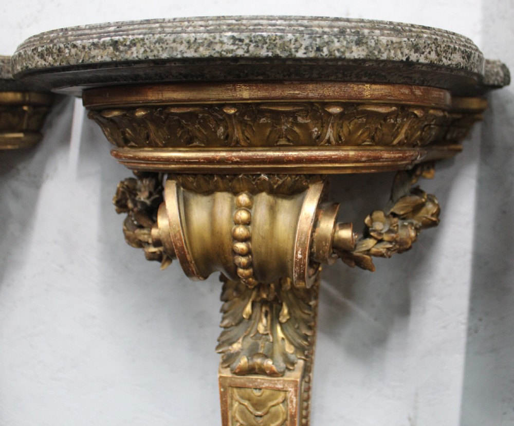 A pair of wall-mounted giltwood console tables with single carved scroll bracket legs and shaped marble tops. View III