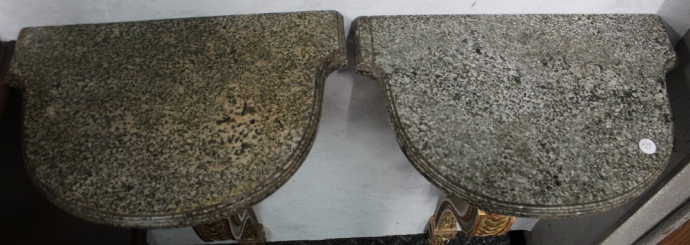 A pair of wall-mounted giltwood console tables with single carved scroll bracket legs and shaped marble tops. View VII