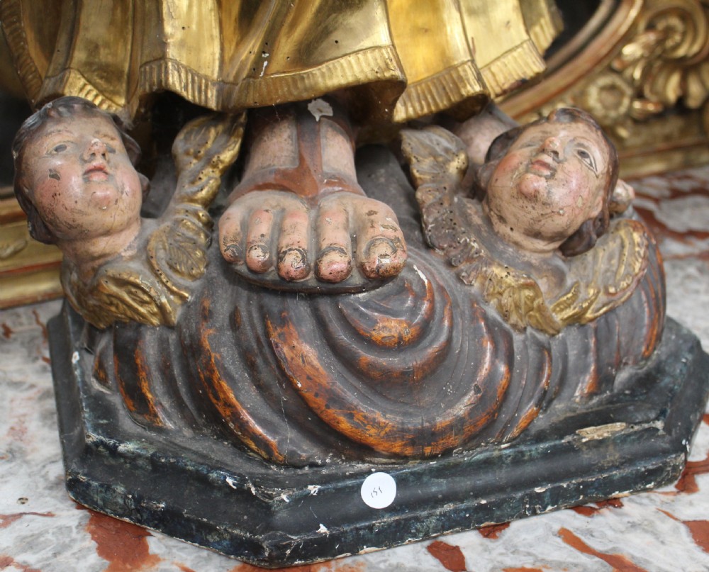 A carved wooden statue depicting Saint Joseph holding the infant Jesus, finished with gold leaf gilding and painted features atop a cherub base. View IV
