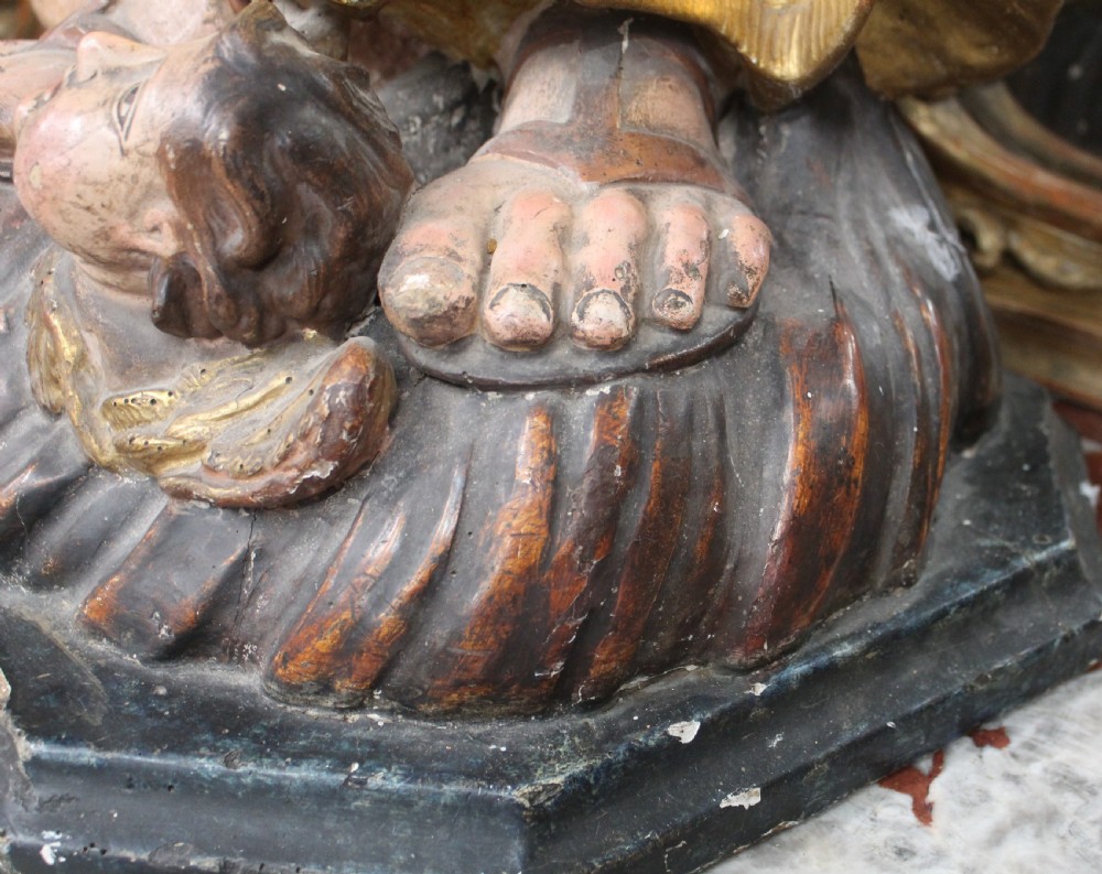 A carved wooden statue depicting Saint Joseph holding the infant Jesus, finished with gold leaf gilding and painted features atop a cherub base. View VII