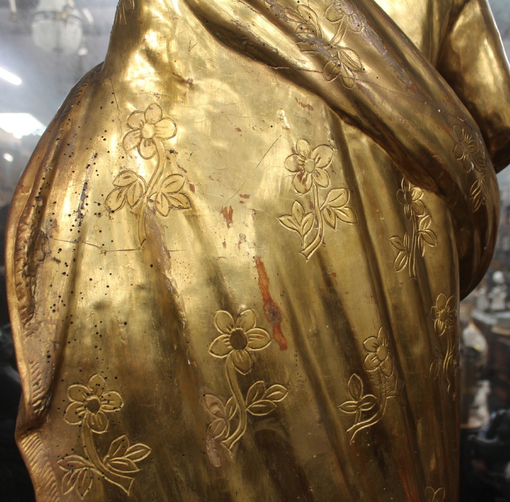 A carved wooden statue depicting Saint Joseph holding the infant Jesus, finished with gold leaf gilding and painted features atop a cherub base. View X