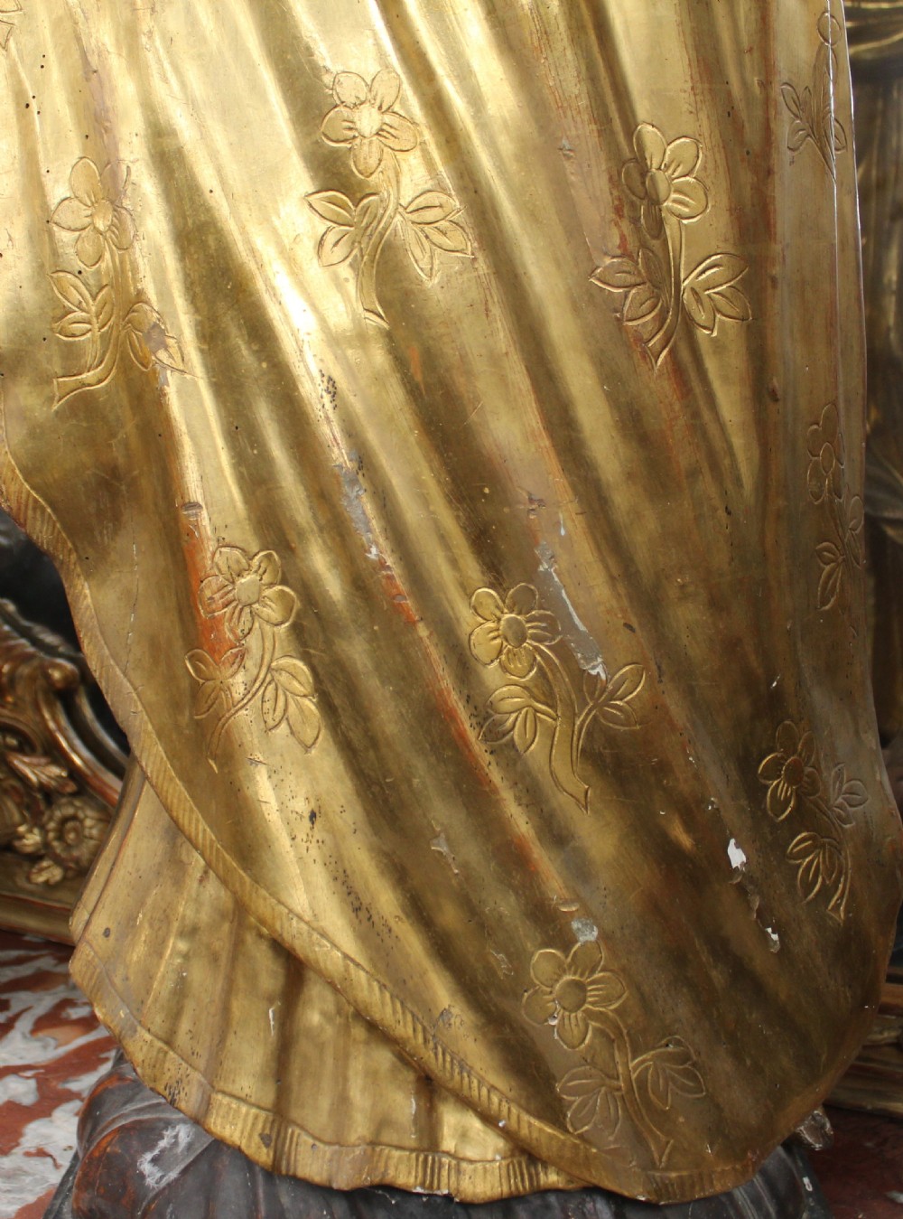 A carved wooden statue depicting Saint Joseph holding the infant Jesus, finished with gold leaf gilding and painted features atop a cherub base. View XI