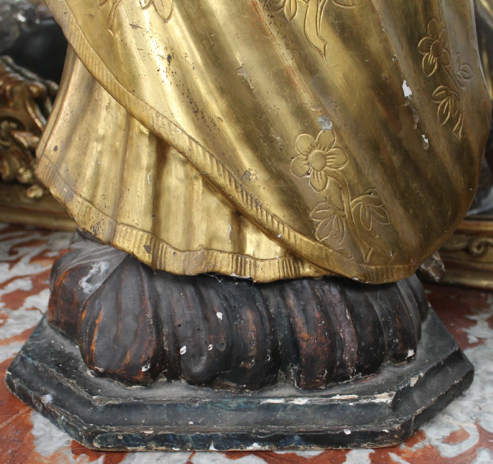 A carved wooden statue depicting Saint Joseph holding the infant Jesus, finished with gold leaf gilding and painted features atop a cherub base. View XII