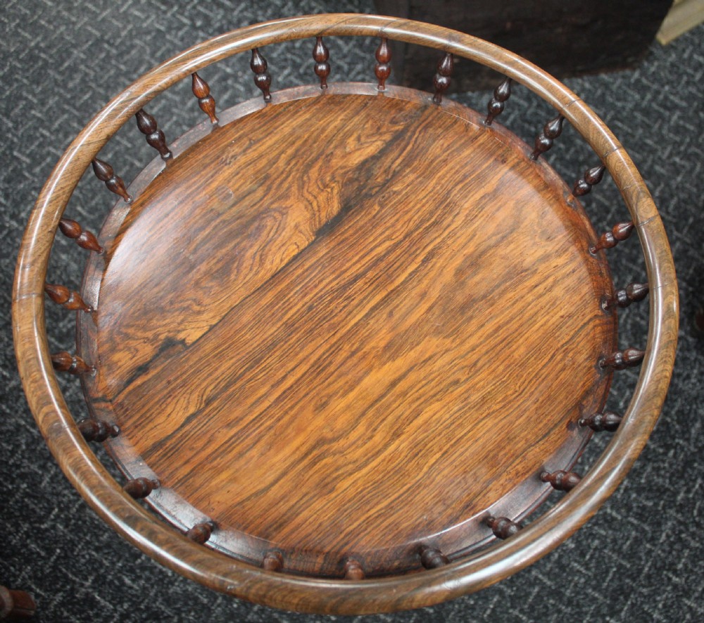 A dark rosewood circular wine table featuring a spindled gallery rim, a turned column stem, and a carved lobed base. View II