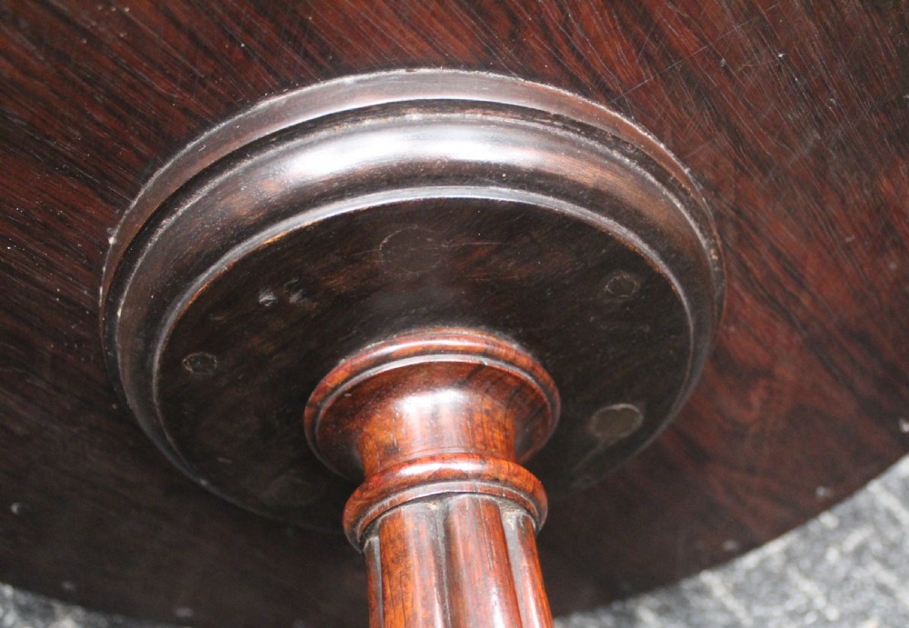 A dark rosewood circular wine table featuring a spindled gallery rim, a turned column stem, and a carved lobed base. View VI