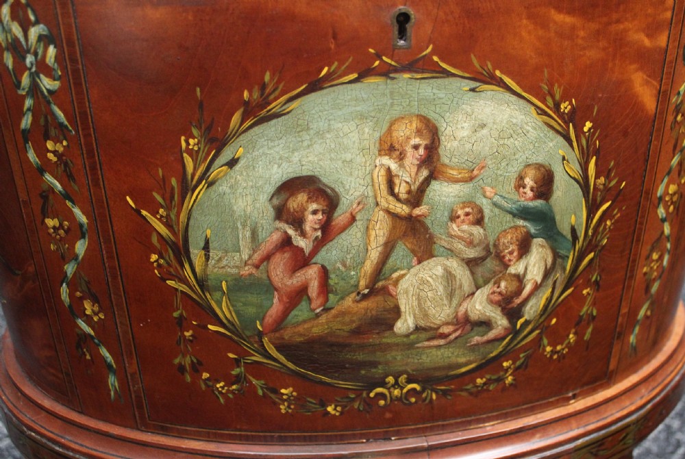 An oval antique satinwood wine cooler featuring hand-painted figurative scenes and floral garlands supported by tapered legs. View II