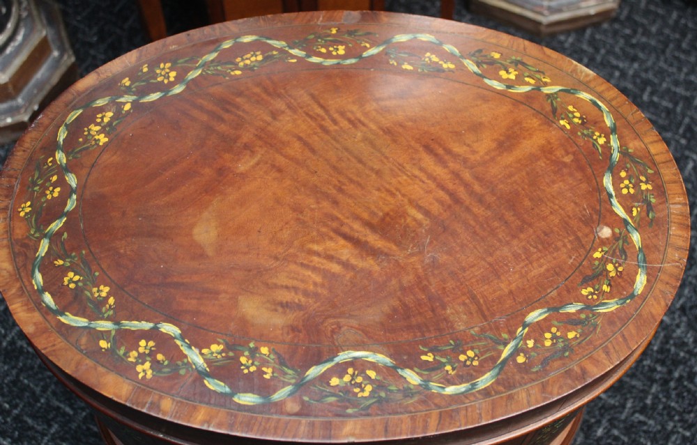 An oval antique satinwood wine cooler featuring hand-painted figurative scenes and floral garlands supported by tapered legs. View VII