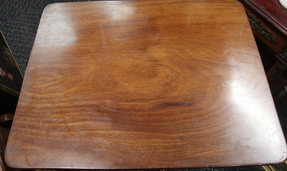 An antique mahogany tilt-top wine table shown with its top tilted upright on a turned pedestal stem and tripod scrolled legs. View VI