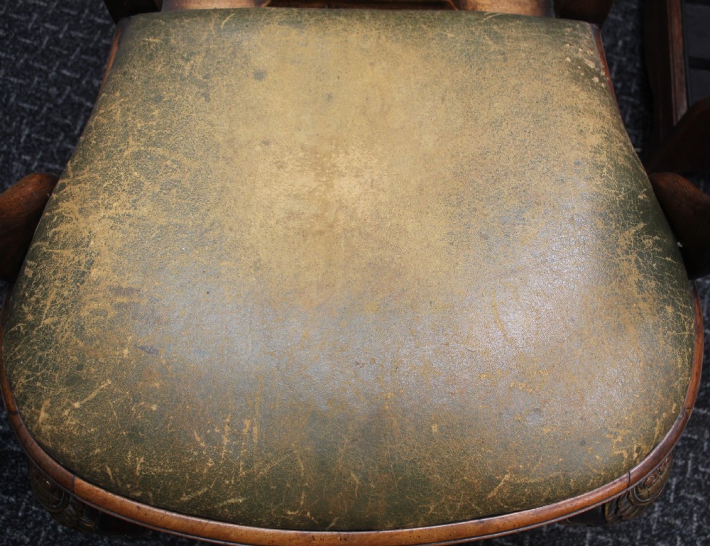 An antique Chippendale style carved mahogany open armchair with a shell crest, pierced splat back, carved cabriole legs, and an aged green leather drop-in seat pad. View V