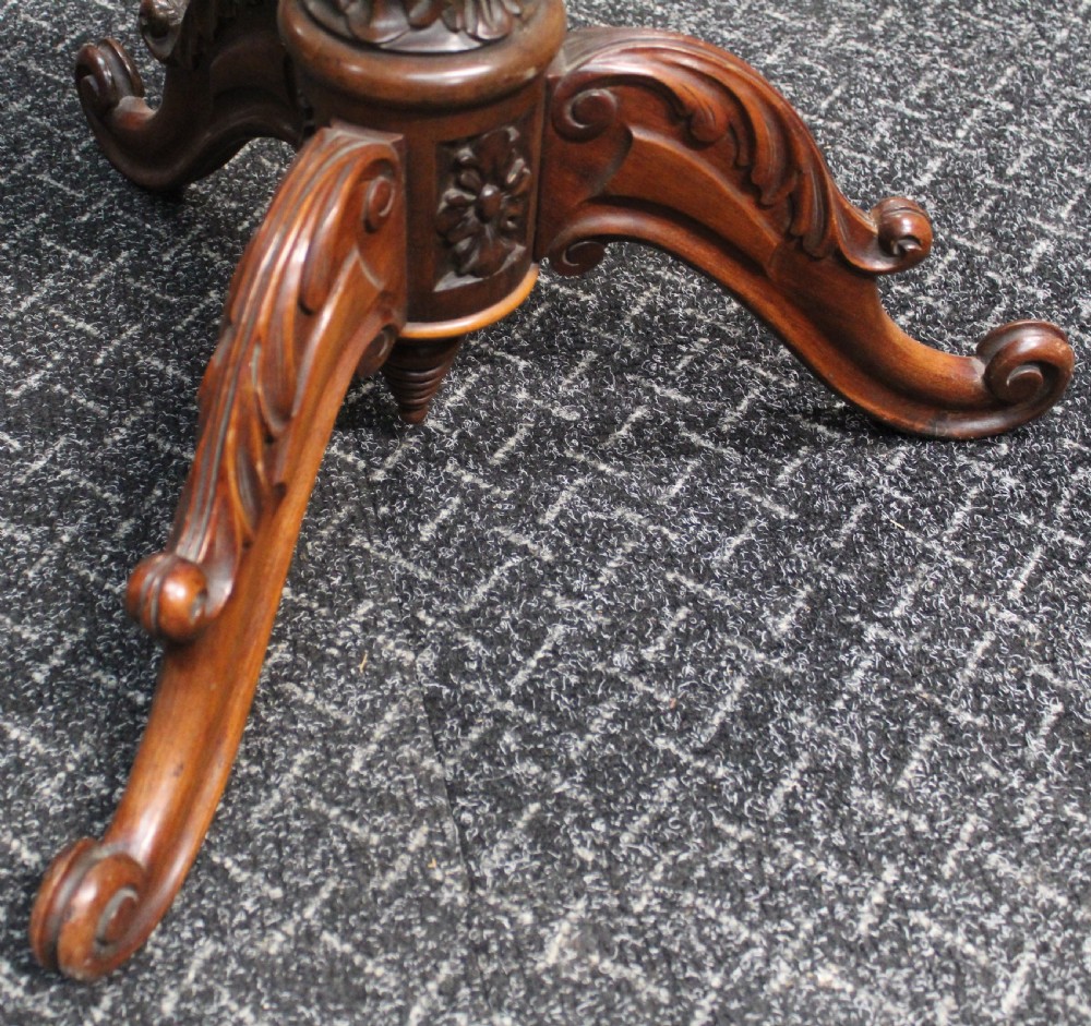 A Victorian circular occasional table featuring a hand-painted floral wreath top enclosed in a gold moulding, supported by a carved wooden pedestal and tripod scroll legs. View V