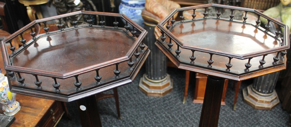 A pair of tall dark mahogany torchere stands featuring octagonal gallery tops, fluted stems, and carved tripod scroll legs. View II