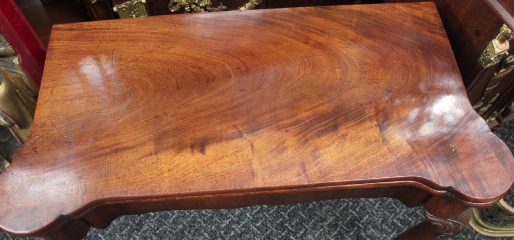 An antique mahogany fold-over games table featuring carved cabriole legs with pad feet and a shaped serpentine top. View II