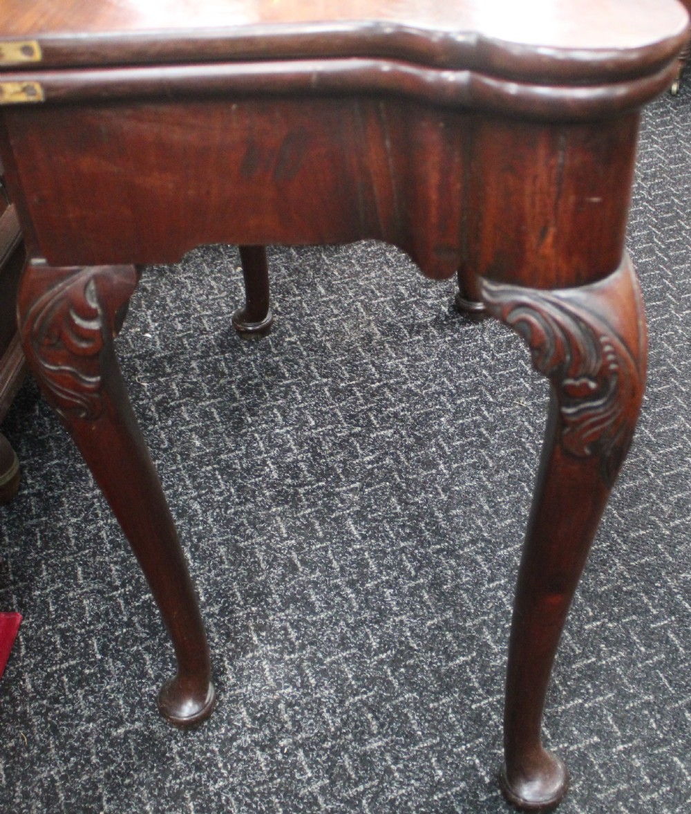 An antique mahogany fold-over games table featuring carved cabriole legs with pad feet and a shaped serpentine top. View IV