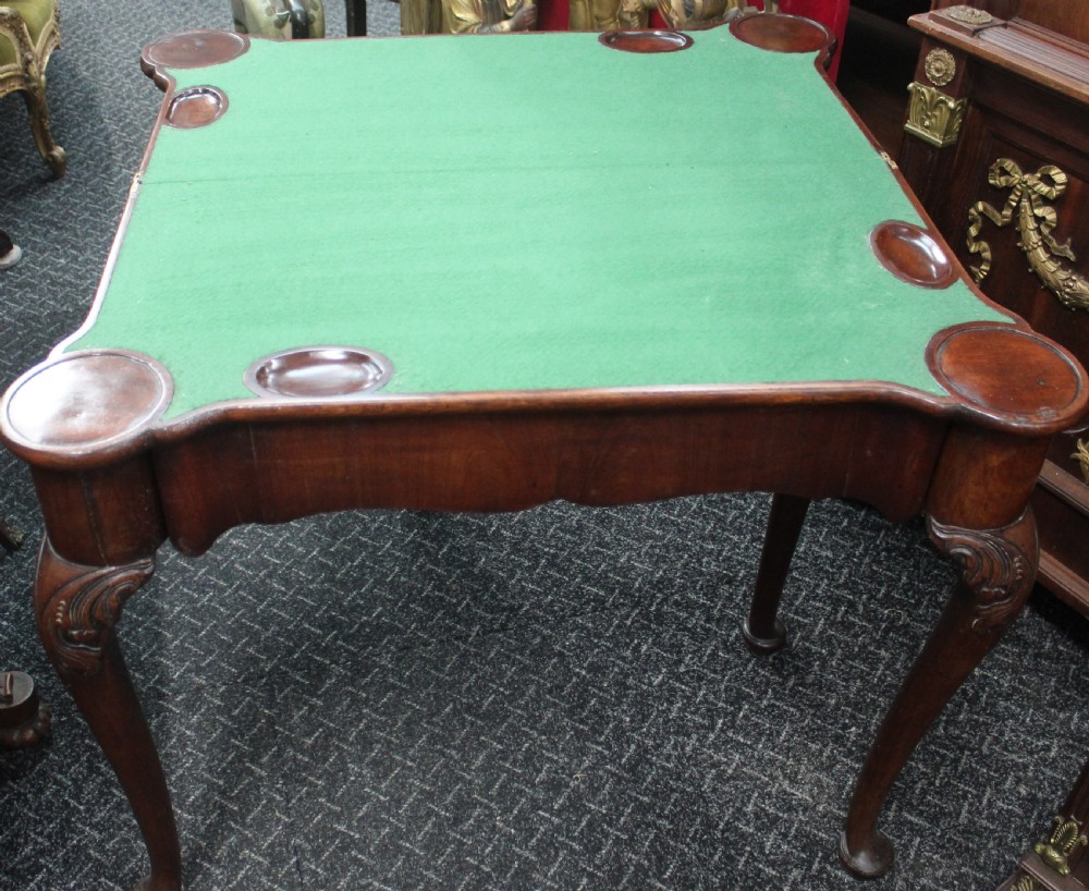 An antique mahogany fold-over games table featuring carved cabriole legs with pad feet and a shaped serpentine top. View V