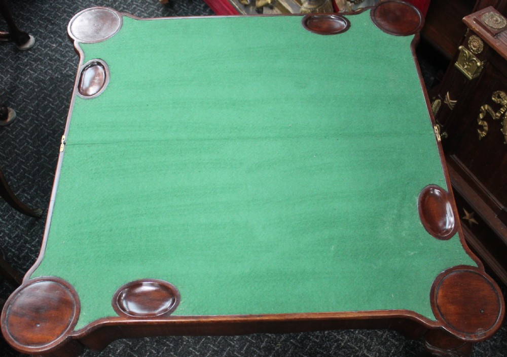 An antique mahogany fold-over games table featuring carved cabriole legs with pad feet and a shaped serpentine top. View VI