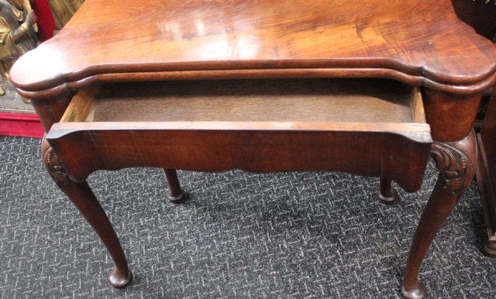 An antique mahogany fold-over games table featuring carved cabriole legs with pad feet and a shaped serpentine top. View VII
